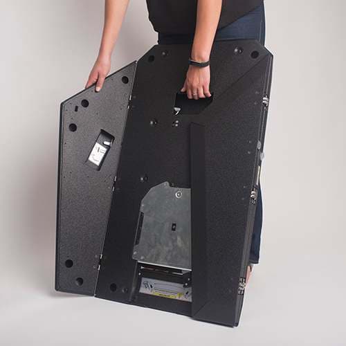 A person lifting the folded PRSU base by its handle, showing how the stand packs down for transport.