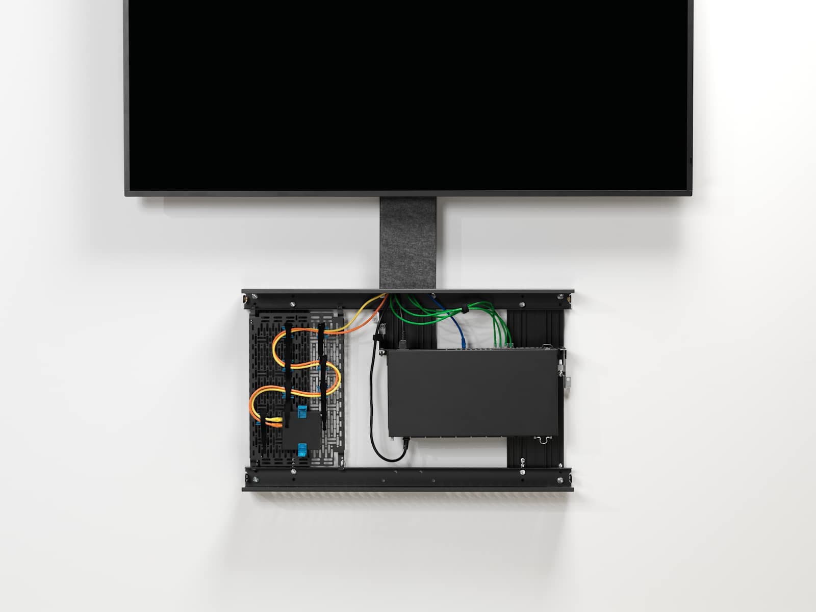 Chief FCASTC Fusion storage cabinet fitted below a wall-mounted landscape display with the felt cover removed, showing cabling and AV devices inside the enclosure.